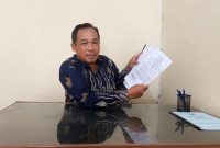 Kades Mulyosri menunjukan dokumen kepemilikan tanah milik desa yang disengketakan. (Foto Al).