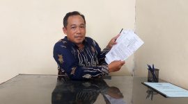 Kades Mulyosri menunjukan dokumen kepemilikan tanah milik desa yang disengketakan. (Foto Al).