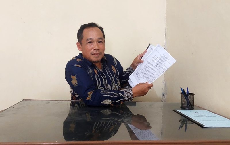 Kades Mulyosri menunjukan dokumen kepemilikan tanah milik desa yang disengketakan. (Foto Al).