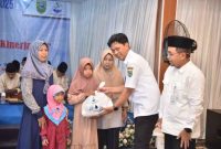 Edi Rianto selaku Sekda Kebumen secara simbolis menyerahkan paket sembako kepada anak yatim dan dhuafa dalam kegiatan Muhasabah Akhir Tahun 2025 di Aula Kantor Pusat PDAM Kebumen.